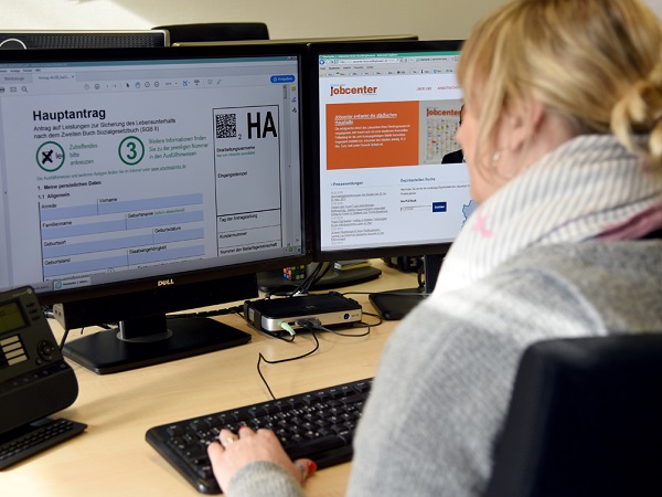 Link zur Seite: Online-Service Eine Frau reicht ihren Antrag auf Grundsicherung am Computer ein.